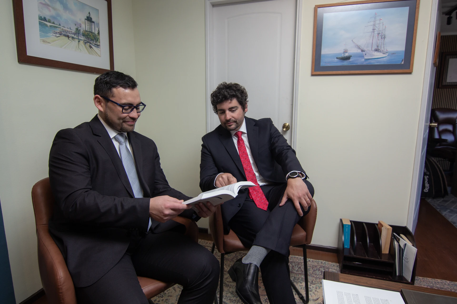 Socios de Lara, Andrade y Cía. revisando un documento en sus oficinas.